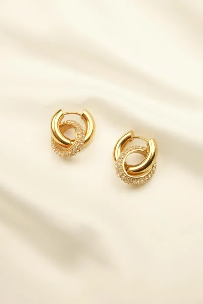 Boucles d'oreilles Riviera. Boucles d'oreilles dorés et en acier inoxydable, composée de doubles anneaux, dont un orné de petits zircons blancs.