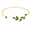 Bracelet Glory vert. Bracelet ajustable doré et en acier inoxydable, en forme de feuille de laurier et orné de zircons verts.